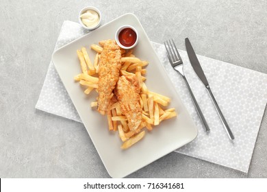 Plate with tasty fried fish and chips on table - Powered by Shutterstock