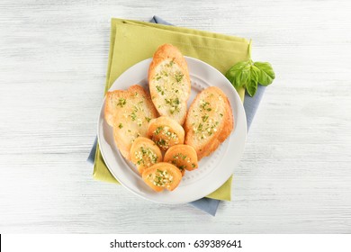 Plate With Tasty Garlic French Bread Slices And Green Napkin