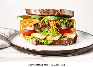 Plate With Tasty Sandwich On Light Wooden Table, Closeup