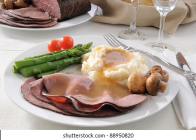 A Plate Of Thin Sliced Roast Beef With Mashed Potatoes And Asparagus