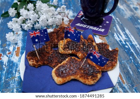 A plate of toast with vegemite, the iconic Australian savoury spread, cut into the shape of Australia as a special breakfast for Australia Day, 26th January.