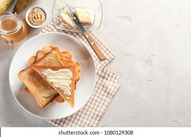 Plate With Toasted Bread And Butter On Table