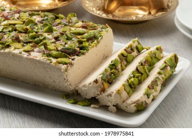 Plate with traditional Turkish pistachio halva and slices close up 