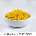 A plate with yellow saffron rice, uncooked rice, and homemade steamed turmeric rice in a bowl