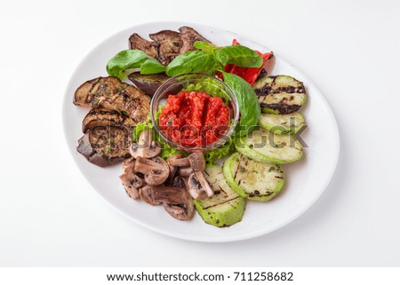 Plateau of delicious grilled vegetables. Eggplant, zucchini, tomatoes, mushrooms.  Restaurant menu. Free space for text. Isolated on white background