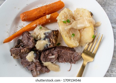 Plated Dinner Of Pot Roast, Carrots, Potatoes, And Gravy