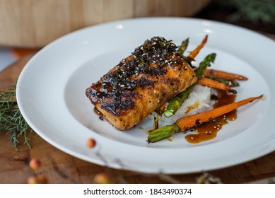 Plated Entree Of Grilled Salmon With Roasted Vegetables, Rice, Carrots, Asparagus -Teriyaki Sauce With Sesame Seeds - Healthy Gourmet Restaurant Meal - Main Dish