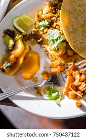 A Plated Filled With A Breakfast Taco. Mango, Avacado, Lime And Diced Sweet Potatoes.