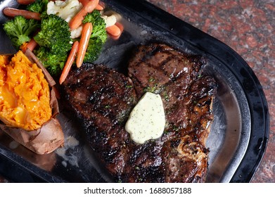 Plated Porter House Steak With Potato And Vegetables.