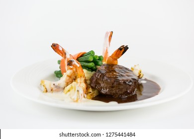 Plated Steak And Shrimp Dinner With Mashed Potato And Green Beans On White Plate.