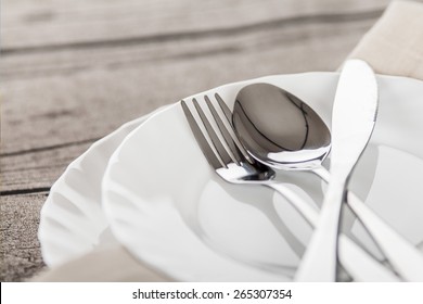 Plates And Cutlery On A Wooden Table