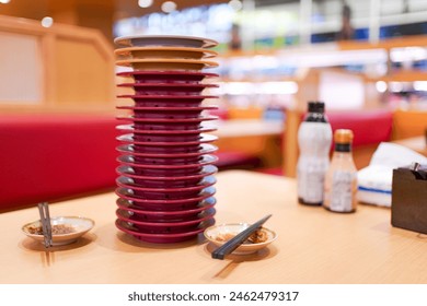 Plates stacked on the table after done on eating. Stacked Sushi plates on the dining table in conveyor belt Sushi bar. - Powered by Shutterstock