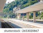 Platform view of Como train station in northern Italy featuring a clear “Como” station sign, tracks, and shelter. Great for travel, transport, and tourism visuals of Italian destinations