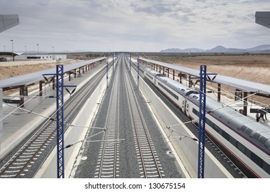 Platforms and rails at Puente Genil railway station with high-speed train - Shutterstock ID 130675154