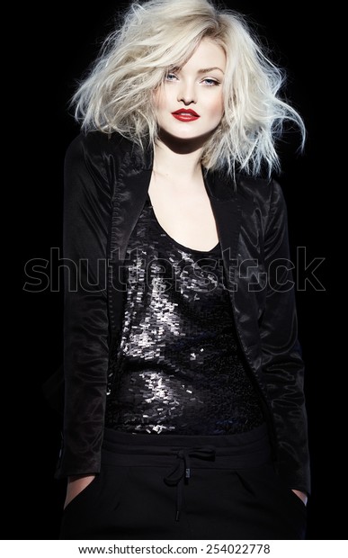 Platinum blond woman in\
black outfit.