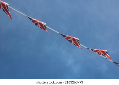 Platinum Jubilee Union Jack bunting across deep blue sky with copy space - Powered by Shutterstock