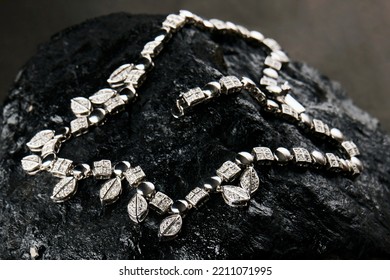 Platinum necklace with diamonds on black background with copy space. Silver necklace on black coal texture, close-up - Shutterstock ID 2211071995