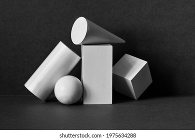 Platonic solids figures geometry. Abstract geometrical objects still life composition. Three-dimensional rectangular prism, cylinder pyramid cube, sphere on black gray background. - Shutterstock ID 1975634288