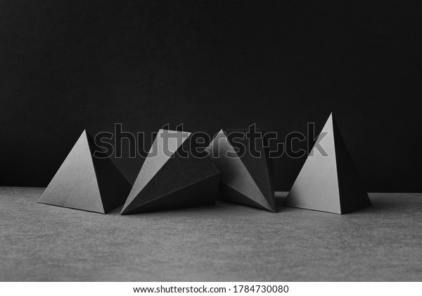 Platonic solids figures geometry. Abstract\
geometrical figures still life composition. Three-dimensional prism\
pyramid objects on black gray\
background