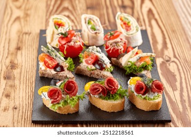 A platter of appetisers  filled with fresh vegetables, ham, and cheese, garnished with basil. Perfect for parties or gatherings, these colorful pinwheel appetizers are vibrant and delicious. - Powered by Shutterstock