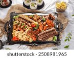 Platter, Arabic Platter, Mix Grill Platter with chicken tikka, beef kabab, mutton kebab, seekh kabab and lamb chop with salad and fries served in dish isolated wooden table top