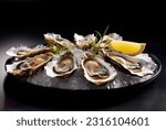 Platter of fresh oysters on a bed of ice. Oysters with lemon and sauce. Several oysters on a tray with caviar. Food in a restaurant. A bowl of oysters with caviar. 