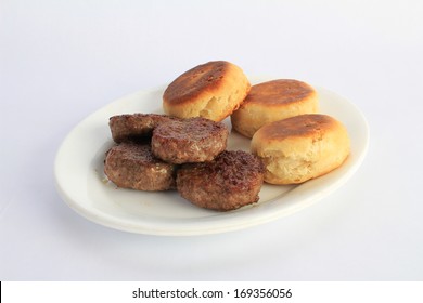 Platter Of Fried Sausage Patties And Baked Biscuits In Bright Morning Light, Ready For The Breakfast Table.