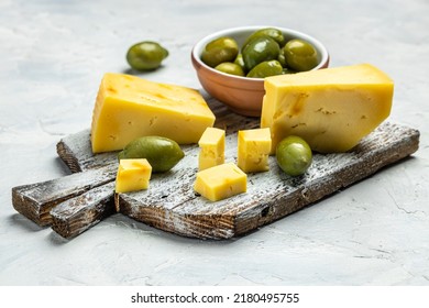 Platter With Sliced Italian Hard Cheese Pecorino Toscano, Homemade Olives On Old Wooden Board Light Background. Food Recipe Background. Close Up.