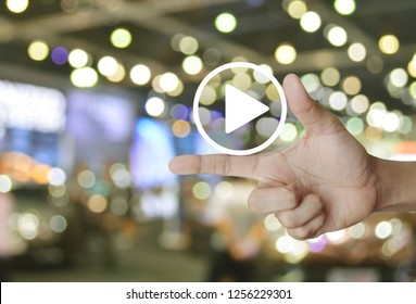 Play button flat icon on finger over blur light and shadow of shopping mall, Business music online concept