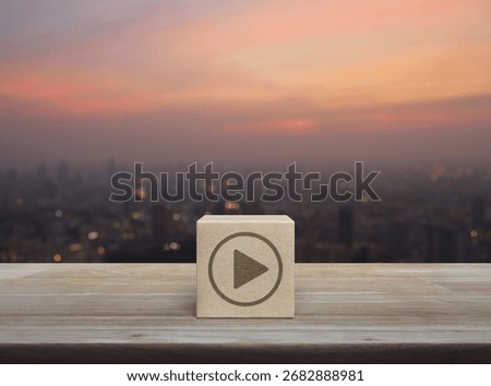 Play button flat icon on wood block cube on wooden table over blur of cityscape on warm light sundown, Business music online concept