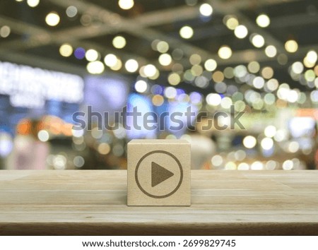 Play button flat icon on wood block cube on wooden table over blur light and shadow of shopping mall, Business music online concept