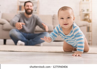 Play With Me. Adorable Baby Boy Crawling On Floor At Home, Daddy Watching His Son, Copy Space