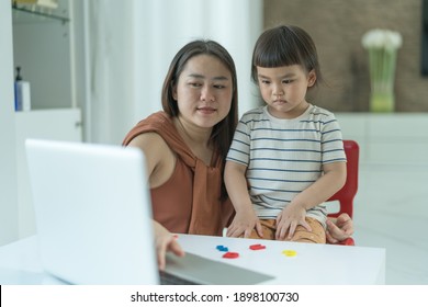 Play time, Cute little girl Pre-school learning game activities  with VDO online learning  with mother beside. New normal style.
