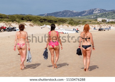 PLAYA DE BOLONIA, SPAIN - MAY 6, 2018:Cellulite skin of a girls walking along the beach