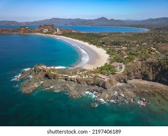 Playa Flamingo, Guanacaste, Costa Rica - Aerial Drone shot of Flamingo Beach South Ridge with panoramic View over Playa Potrero - Luxury Homes on Cliff and Rock Formation on the Pacific Coast line