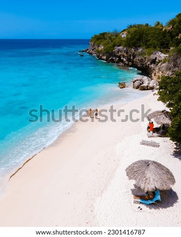 Playa Kalki Beach Caribbean island of Curacao, Playa Kalki in Curacao, white beach with a blue turqouse colored ocean. Drone aerial view of a couple of men and women at the beach