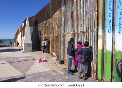 PLAYAS DE TIJUANA, MEXICO - JANUARY 28, 2017: Mexican families living in Tijuana visit with family living in the U.S. by meeting at the border wall in Playas de Tijuana on a sunny Saturday morning.