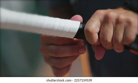 Player changing racquet tennis grip. Person replacing overgrip closeup hand renewing sport equipment