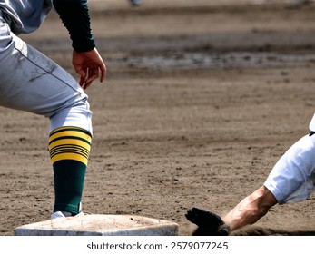 A player doing a head slide to return to first base in a baseball game