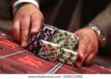 Player at gambling table pusing large stack of chips