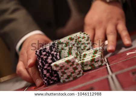 Player at gambling table pusing large stack of chips