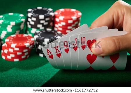 Player looking at cards. Winning poker hand royal flush.