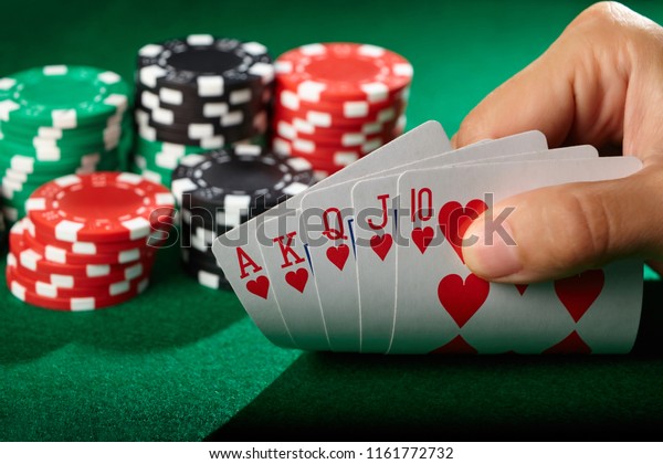 Player\
looking at cards. Winning poker hand royal\
flush.