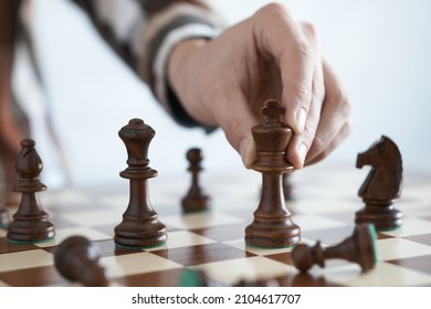 The player moves the king piece, Holds the king chess piece with his hand to make a move. Leisure play at home, leadership skills, strategic thinking - Shutterstock ID 2104617707