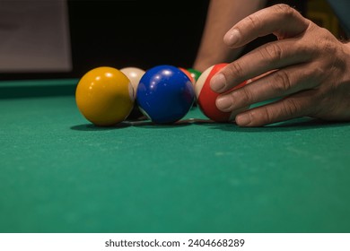 the player places the balls on the billiard table. playing billiards relaxing after a working day. copy space.