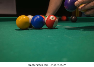 the player places the balls on the billiard table. playing billiards relaxing after a working day.