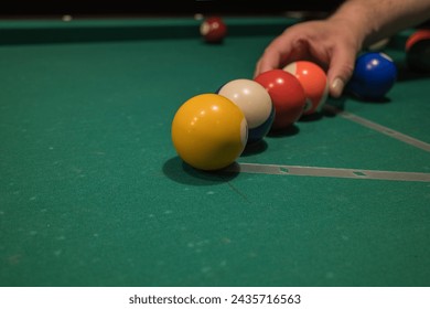 the player places the balls on the billiard table. playing billiards relaxing after a working day.