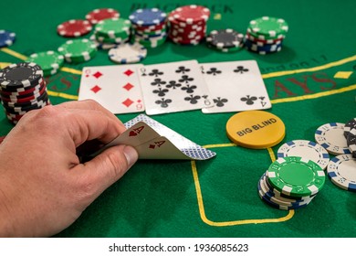 player shows two play card aces on a green table in a casino wirh chips. gambling