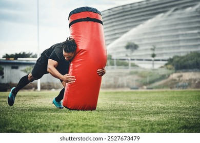 Player, tackle and rugby on field for bag, competition and sports match with fitness, physical and active. Man, gear and athlete outdoor at stadium for workout, exercise and start with determination - Powered by Shutterstock