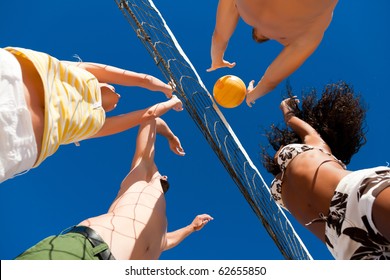 Players doing summer sports trying to block a dangerous attack in a beach volleyball game